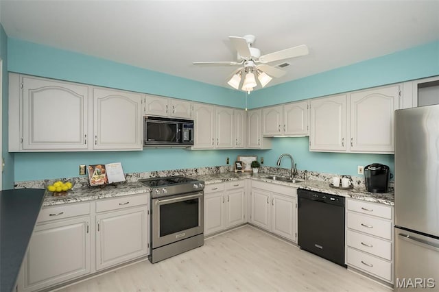 12 Country Club Ter, Glendale, MO 63122 - kitchen with black appliances, a sink, light stone countertops, and light wood-style floors