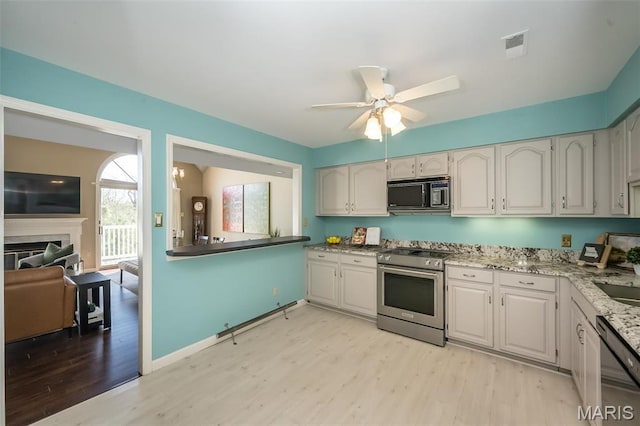 12 Country Club Ter, Glendale, MO 63122 - kitchen with stainless steel electric range oven, black microwave, dishwasher, light wood-style floors, and ceiling fan