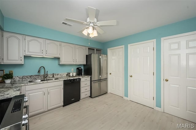 12 Country Club Ter, Glendale, MO 63122 - kitchen featuring stainless steel appliances, a sink, light wood finished floors, a ceiling fan, and light stone counters