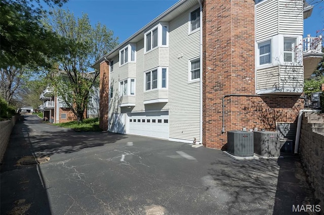12 Country Club Ter, Glendale, MO 63122 - view of building exterior featuring a garage, driveway, and central AC unit