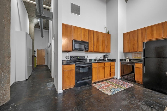 1511 Locust St Unit 101, Saint Louis, MO 63103 - kitchen featuring black appliances, a high ceiling, finished concrete flooring, brown cabinets, and dark countertops