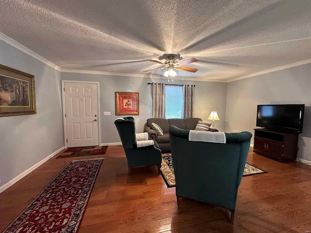 living room with baseboards, ceiling fan, crown molding, wood finished floors, and a textured ceiling