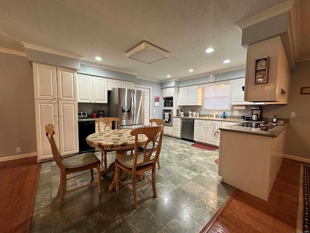 kitchen with black appliances, crown molding, baseboards, a sink, and a peninsula