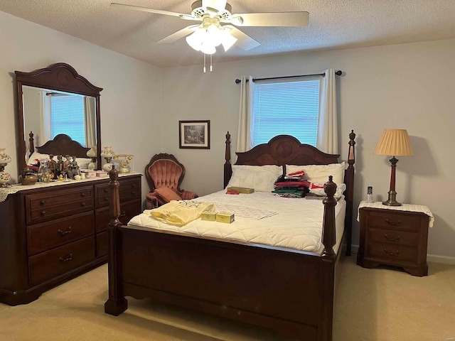 bedroom with light carpet, multiple windows, a ceiling fan, and a textured ceiling