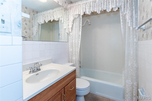 bathroom featuring tile walls, shower / bath combo with shower curtain, toilet, and vanity