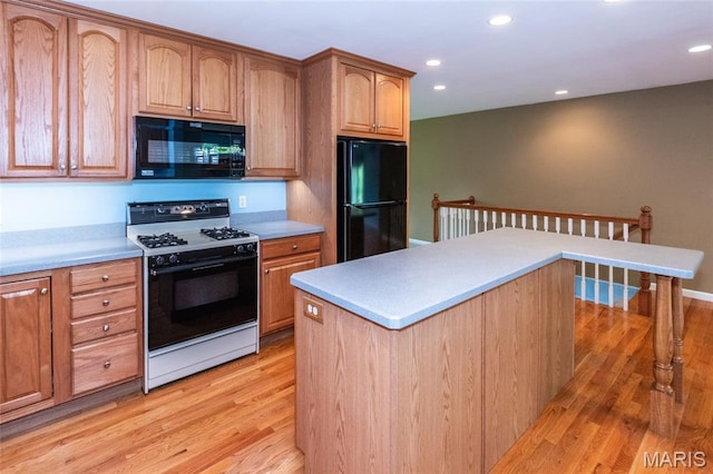 kitchen featuring black appliances, light wood-style floors, light countertops, recessed lighting, and brown cabinets