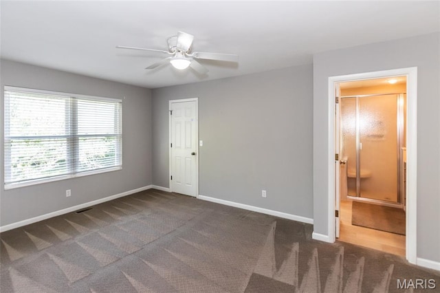 carpeted empty room with a ceiling fan and baseboards
