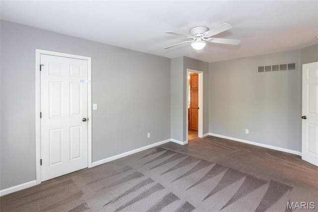 unfurnished bedroom with dark carpet, baseboards, and ceiling fan