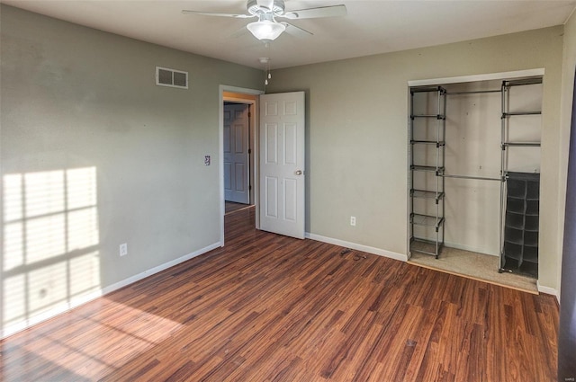 unfurnished bedroom featuring baseboards, wood finished floors, a closet, and ceiling fan