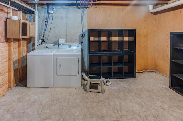 unfinished basement featuring independent washer and dryer, wood walls, and carpet floors