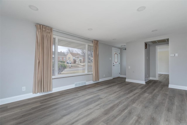 unfurnished living room featuring wood finished floors and baseboards