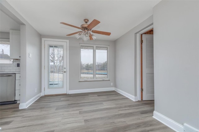 unfurnished living room featuring ceiling fan, light wood-style floors, and baseboards