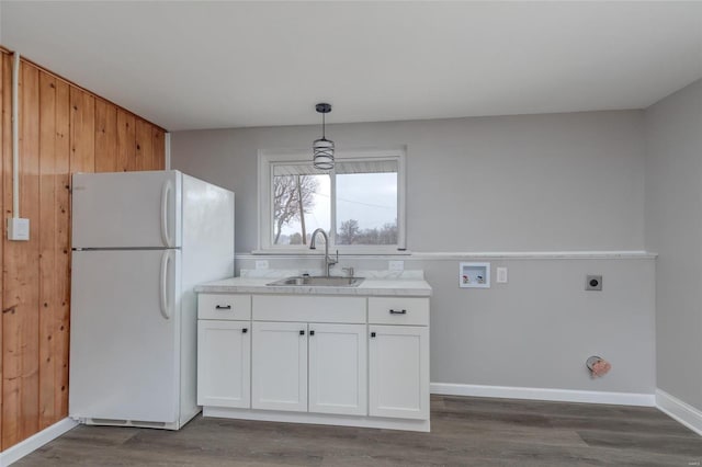 kitchen with a sink, freestanding refrigerator, white cabinets, and dark wood finished floors