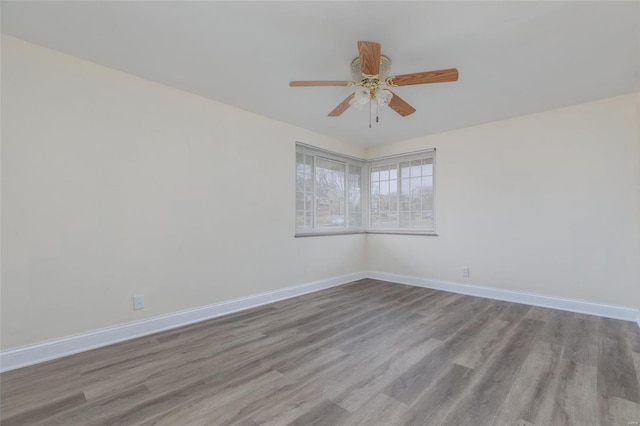 empty room featuring wood finished floors, ceiling fan, and baseboards