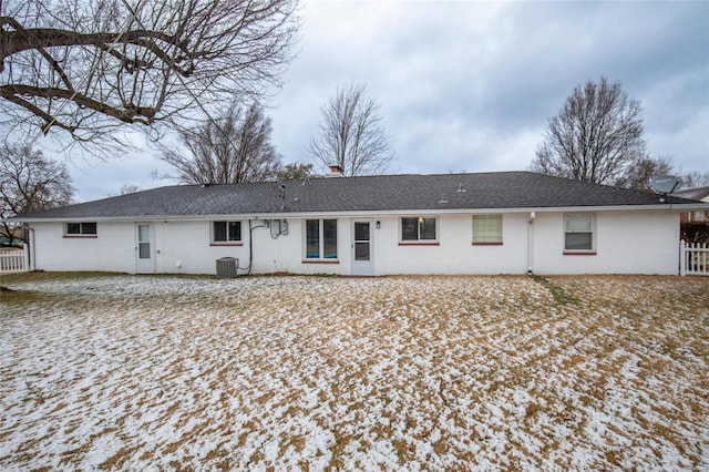 back of property with central AC, fence, and a shingled roof