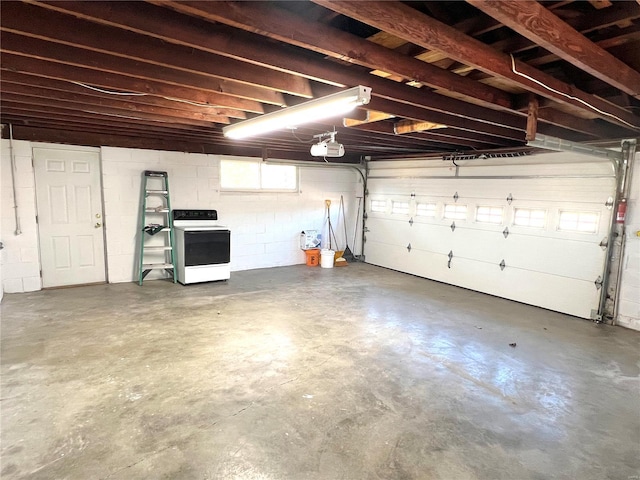 garage featuring a garage door opener, concrete block wall, and washer / dryer