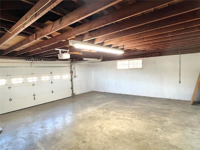 garage featuring concrete block wall and a garage door opener