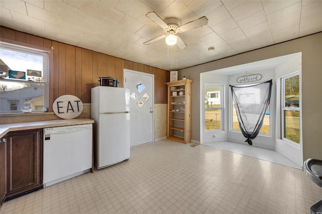 402 Virginia Ave, Potosi, MO 63664 - kitchen featuring white appliances, wood walls, light countertops, a ceiling fan, and light flooring