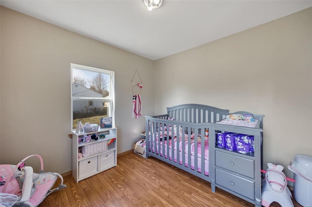 402 Virginia Ave, Potosi, MO 63664 - bedroom with wood finished floors, a nursery area, and baseboards