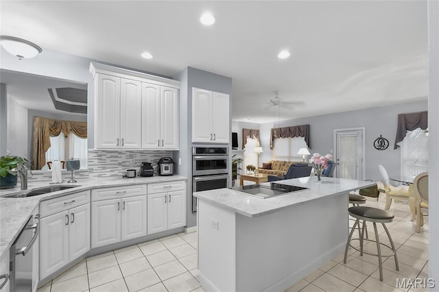 12537 Clark Manor Cir, Creve Coeur, MO 63141 - kitchen with a sink, stainless steel appliances, a breakfast bar area, light tile patterned floors, and recessed lighting