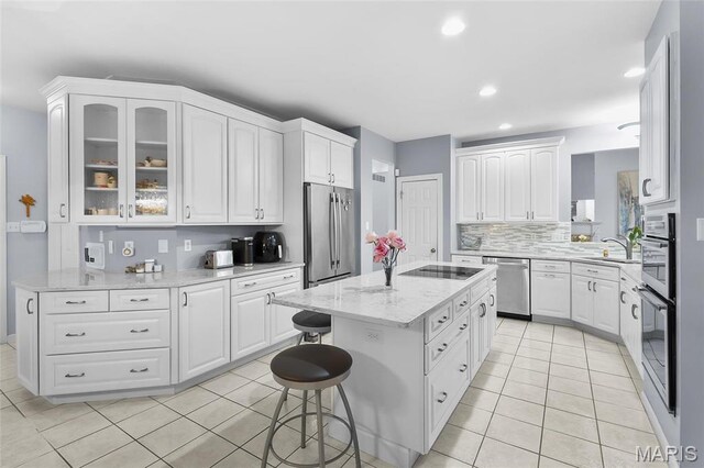 12537 Clark Manor Cir, Creve Coeur, MO 63141 - kitchen with stainless steel appliances, a kitchen bar, a center island, light tile patterned flooring, and recessed lighting