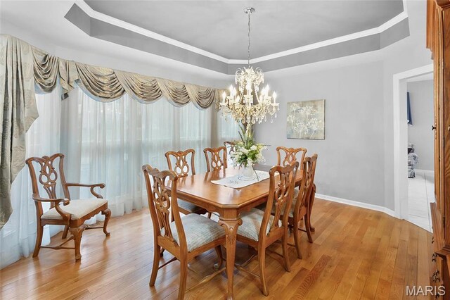 12537 Clark Manor Cir, Creve Coeur, MO 63141 - dining area featuring a raised ceiling, light wood-style floors, and a chandelier