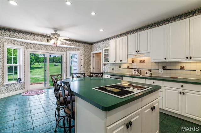 11400 State Road C, Hillsboro, MO 63050 - kitchen featuring stovetop with downdraft, wallpapered walls, dark countertops, a sink, and white cabinetry