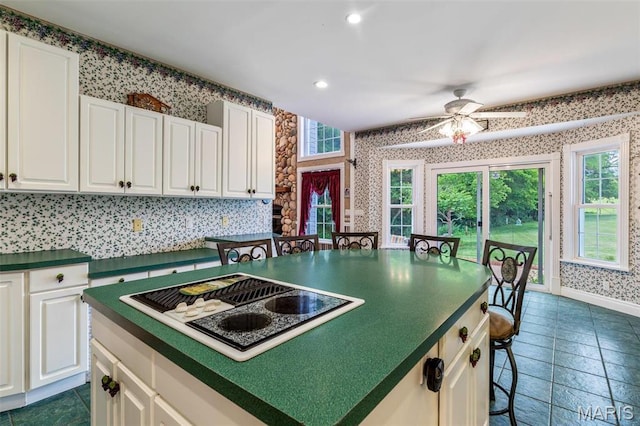 11400 State Road C, Hillsboro, MO 63050 - kitchen with white electric stovetop, wallpapered walls, dark countertops, white cabinetry, and recessed lighting
