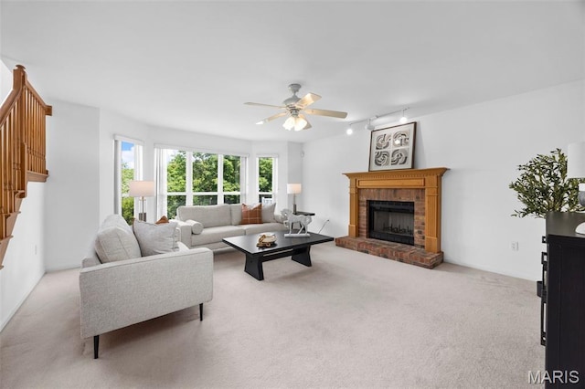 1214 Westrun Dr, Ballwin, MO 63021 - living room featuring carpet floors, stairs, a ceiling fan, a brick fireplace, and rail lighting