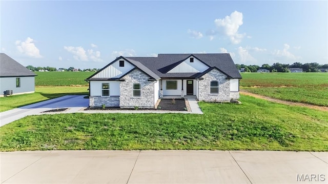 1002 Brianna Ct, Jerseyville, IL 62052 - view of front of home with stone siding, board and batten siding, a front yard, and driveway