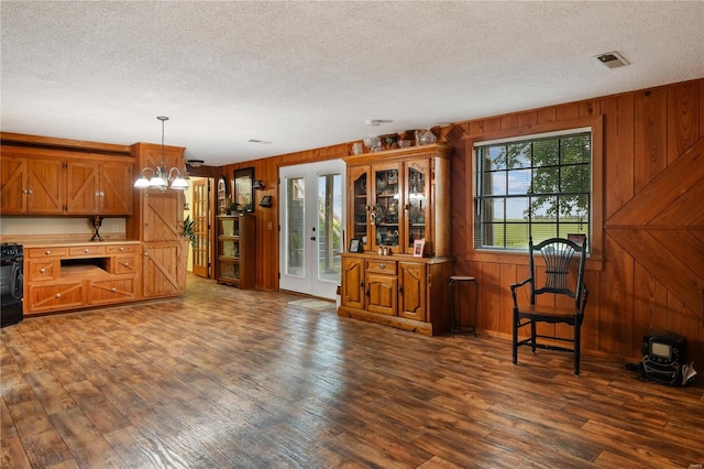 6492 State Highway 25, Dexter, MO 63841 - kitchen with a textured ceiling, light countertops, wooden walls, dark wood-type flooring, and brown cabinets