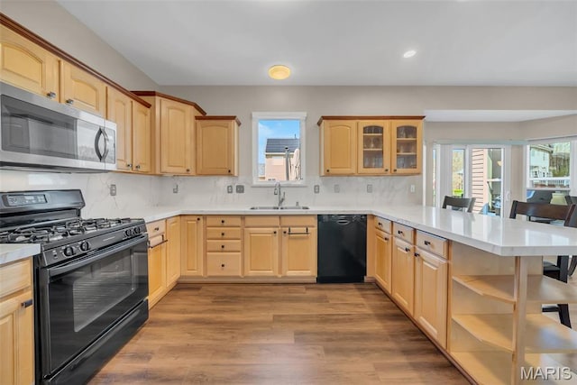 1101 Panda Ct, Wentzville, MO 63385 - kitchen featuring black appliances, a sink, a peninsula, light brown cabinetry, and recessed lighting