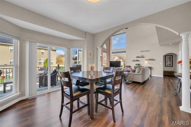 1101 Panda Ct, Wentzville, MO 63385 - dining room featuring arched walkways, decorative columns, plenty of natural light, and dark wood-type flooring