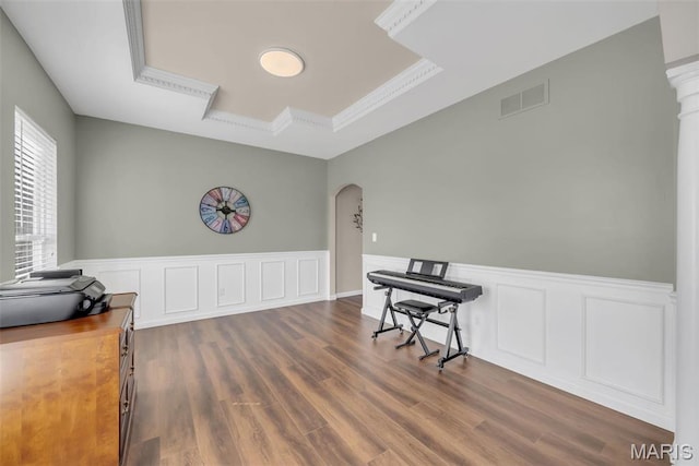 1101 Panda Ct, Wentzville, MO 63385 - living area featuring a tray ceiling, arched walkways, dark wood-style flooring, and wainscoting