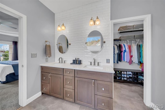 1101 Panda Ct, Wentzville, MO 63385 - bathroom featuring ensuite bathroom, double vanity, baseboards, a spacious closet, and decorative backsplash