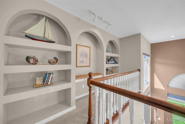 1101 Panda Ct, Wentzville, MO 63385 - hallway featuring built in features, carpet floors, an upstairs landing, rail lighting, and baseboards