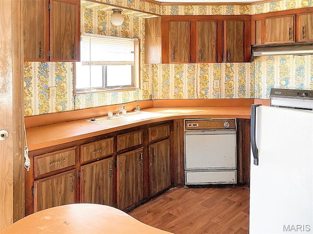 307 Silvey, Fayette, MO 65248 - kitchen featuring wallpapered walls, exhaust hood, wood finished floors, light countertops, and dishwasher