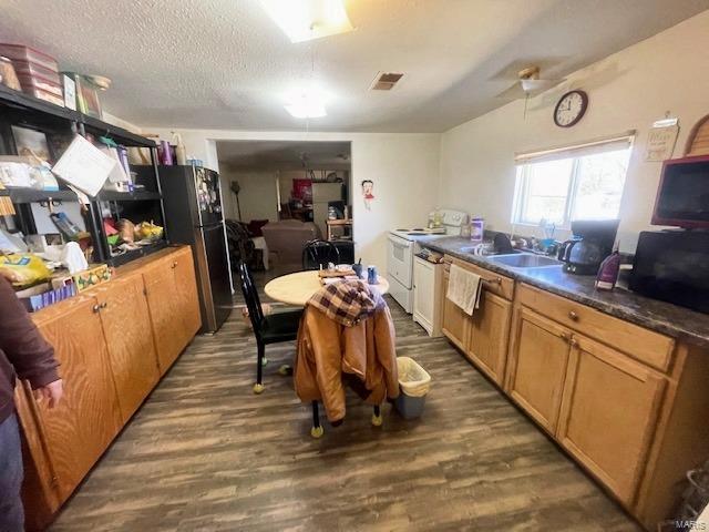 659 W 4th St, Lebanon, MO 65536 - kitchen featuring electric range, wood finished floors, dark countertops, freestanding refrigerator, and a textured ceiling