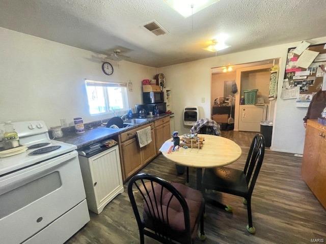 659 W 4th St, Lebanon, MO 65536 - kitchen with white range with electric stovetop, a textured ceiling, heating unit, dark countertops, and a sink
