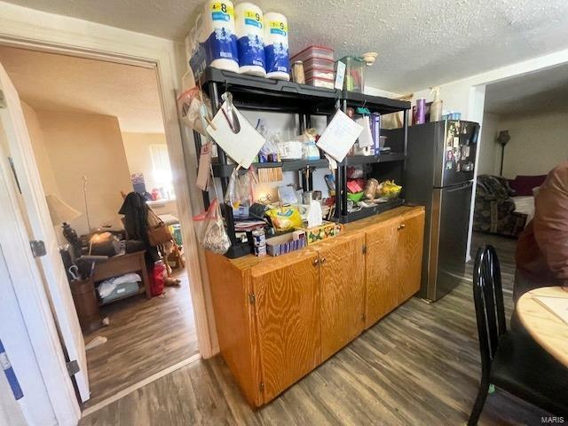 659 W 4th St, Lebanon, MO 65536 - kitchen featuring freestanding refrigerator, wood finished floors, and a textured ceiling