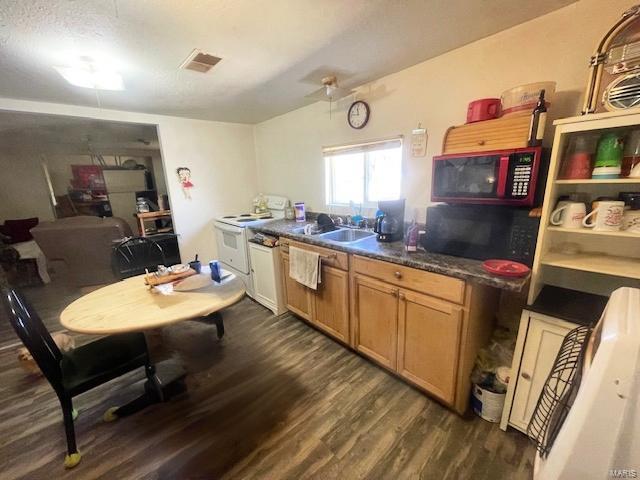659 W 4th St, Lebanon, MO 65536 - kitchen with white electric range, dark wood finished floors, dark countertops, brown cabinetry, and black microwave