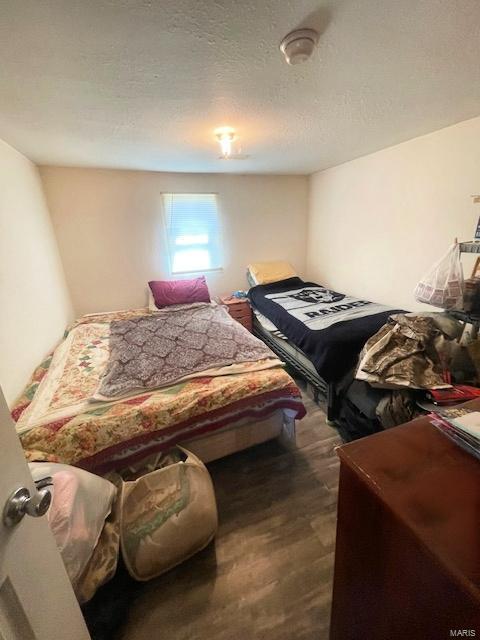 659 W 4th St, Lebanon, MO 65536 - bedroom with wood finished floors and a textured ceiling