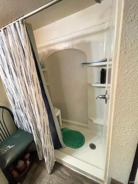659 W 4th St, Lebanon, MO 65536 - full bathroom with a stall shower, wood finished floors, and a textured wall