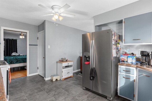 kitchen with stainless steel refrigerator with ice dispenser, ceiling fan, decorative backsplash, range, and baseboards