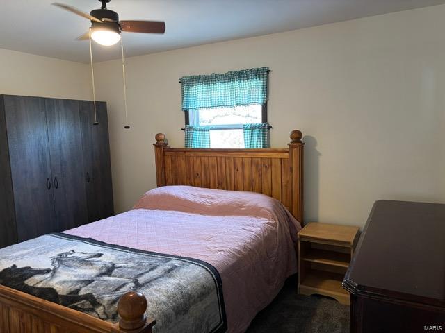 carpeted bedroom featuring a ceiling fan and a closet