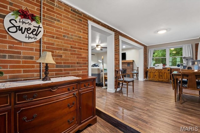 6405 S Ronnie Dr, Waterloo, IL 62298 - interior space with dark wood finished floors, brick wall, and crown molding