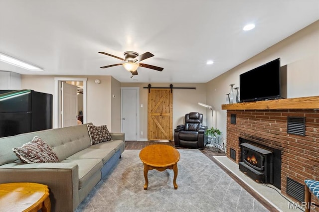 6405 S Ronnie Dr, Waterloo, IL 62298 - living area with a barn door, a wood stove, wood finished floors, a ceiling fan, and recessed lighting