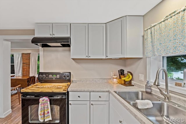 6405 S Ronnie Dr, Waterloo, IL 62298 - kitchen featuring under cabinet range hood, black electric range, light countertops, white cabinets, and wood finished floors