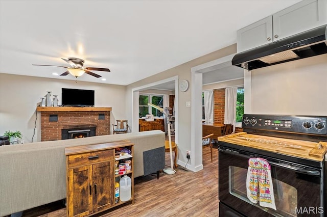 6405 S Ronnie Dr, Waterloo, IL 62298 - kitchen featuring black electric range, under cabinet range hood, light wood-style floors, a ceiling fan, and open floor plan