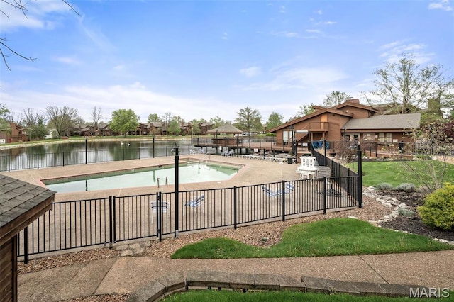 community pool with fence and a water view